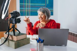 Senior woman smiling and recording a video for social media.