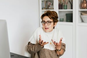 confident female employee having video chat on computer in workspace