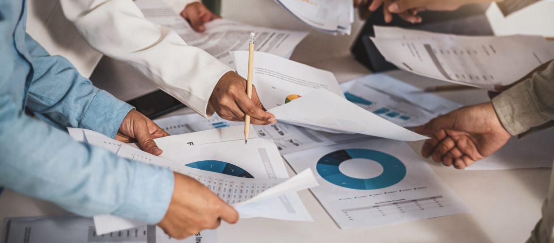 Closeup hands of Business team colleagues working and discussing with various document graph and statistic together in meeting room when brainstorming project management, strategy for success concept